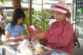 Fruit vendor in Thailand offers pineapple