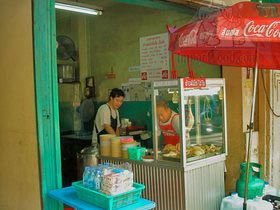 Thai Street Vendor Offers Khao Man Gai from a Shophouse Cart